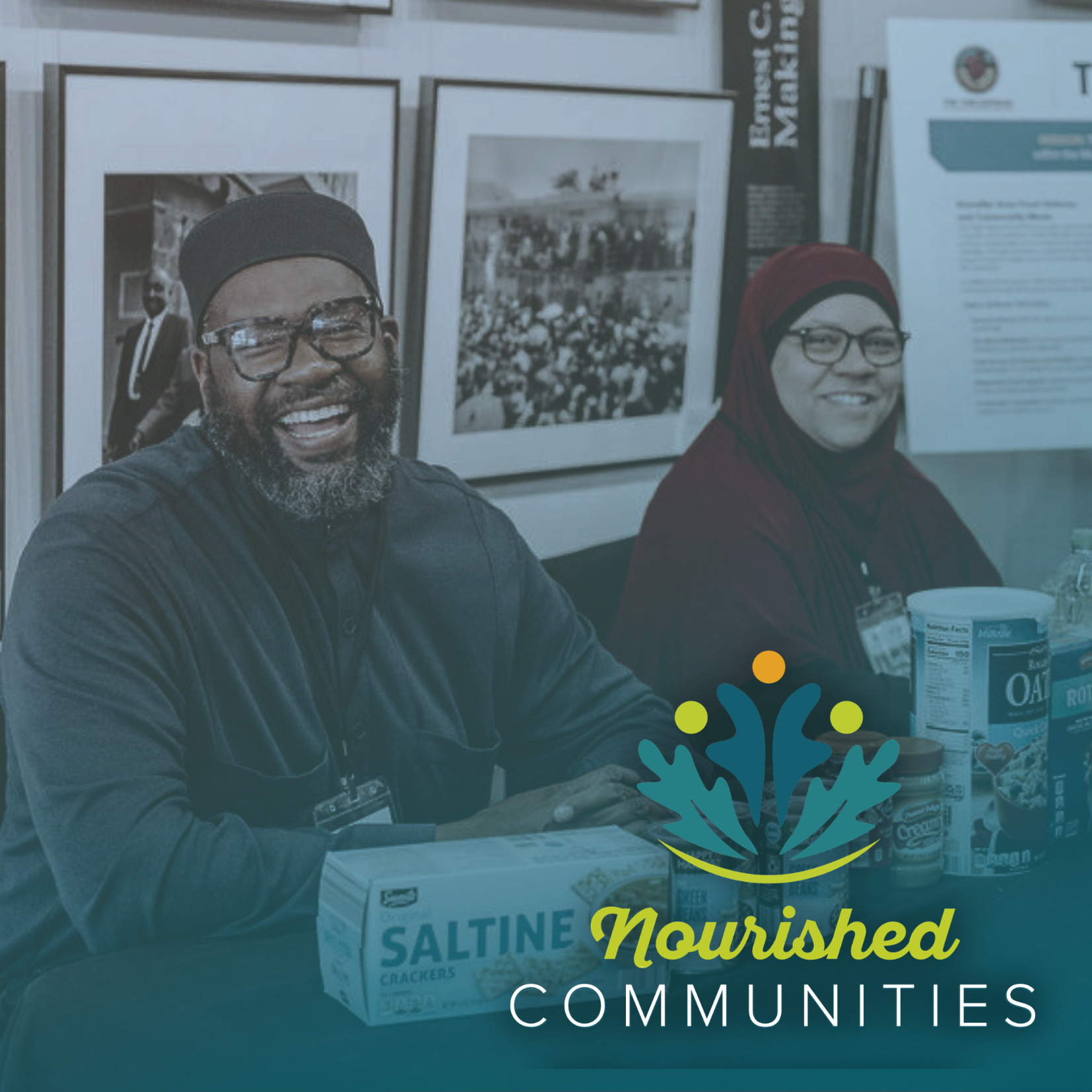 A smiling man and woman sit at a table with food items like saltine crackers and oatmeal, showing community support at an event booth. The Nourished Communities logo is displayed at the bottom of the image.