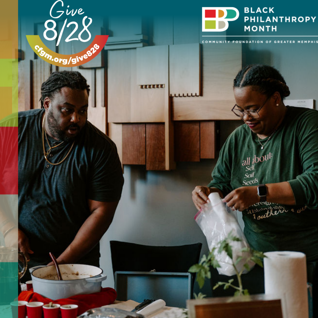 Two people prepare food together in a kitchen. Both wear green shirts, and one person is stirring a pot while the other handles a plastic bag. The image highlights Black Philanthropy Month and Give 8/28, emphasizing support for Black-Led Nonprofits and advancing funding equity within communities.