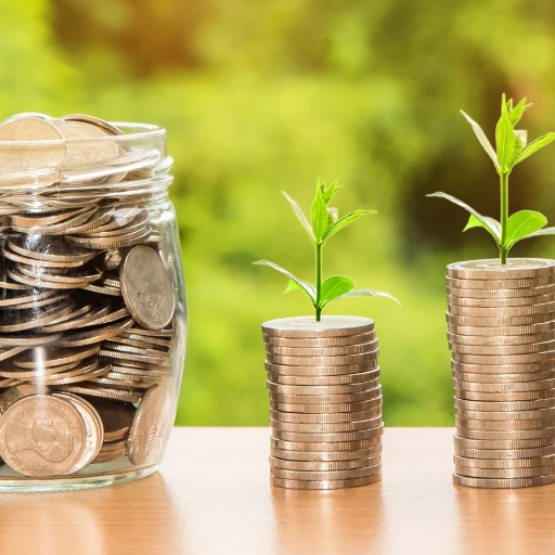 A glass jar and two stacks of coins with small green plants growing out of them, symbolizing bunching as a tax strategy.